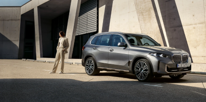 BMW X5 und Person vor modernem Gebäude