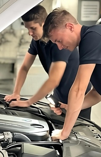 Zwei männlicher Mechatroniker schauen in einen Motorraum